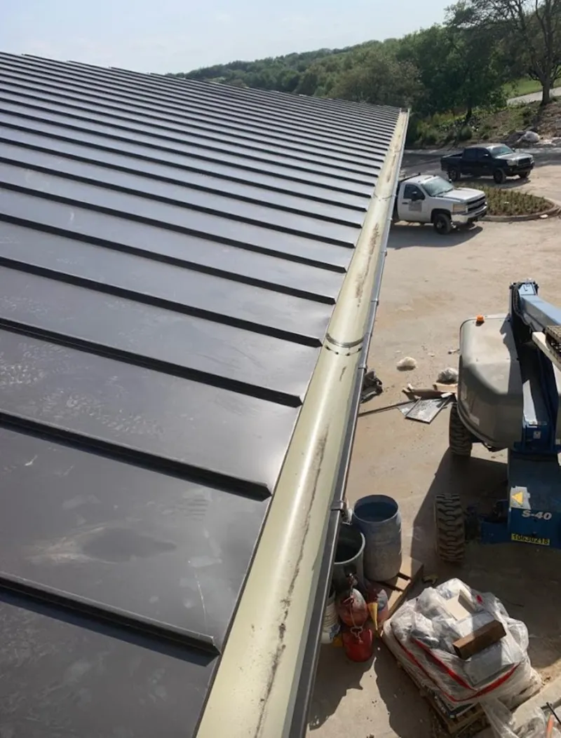 Standing seam panel and gutter detail on a metal roofing jobsite in Aurora